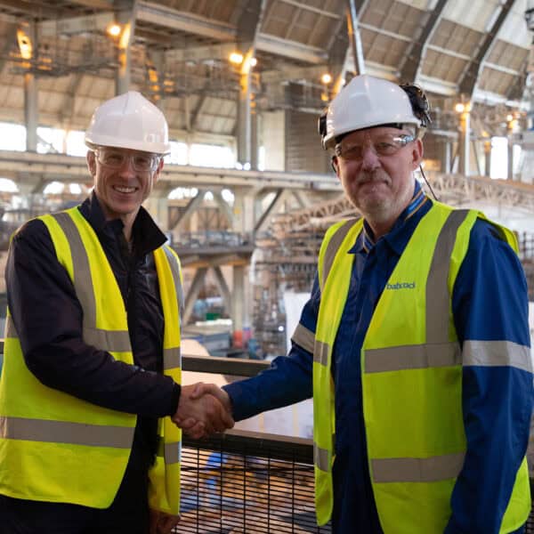 Navy and Babcock representatives shaking hands inside Babcock's frigate support centre