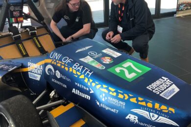 Two people looking at a Formula Student race car