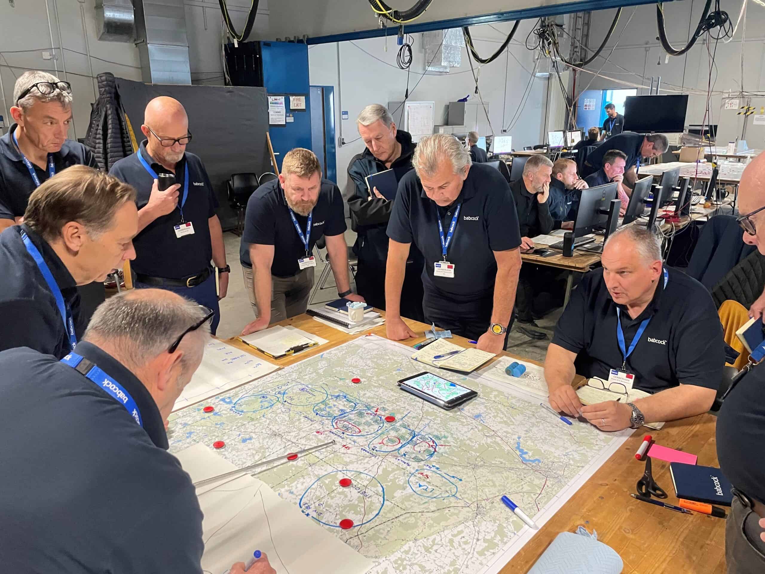 Babcock NATO subject matter experts with military map