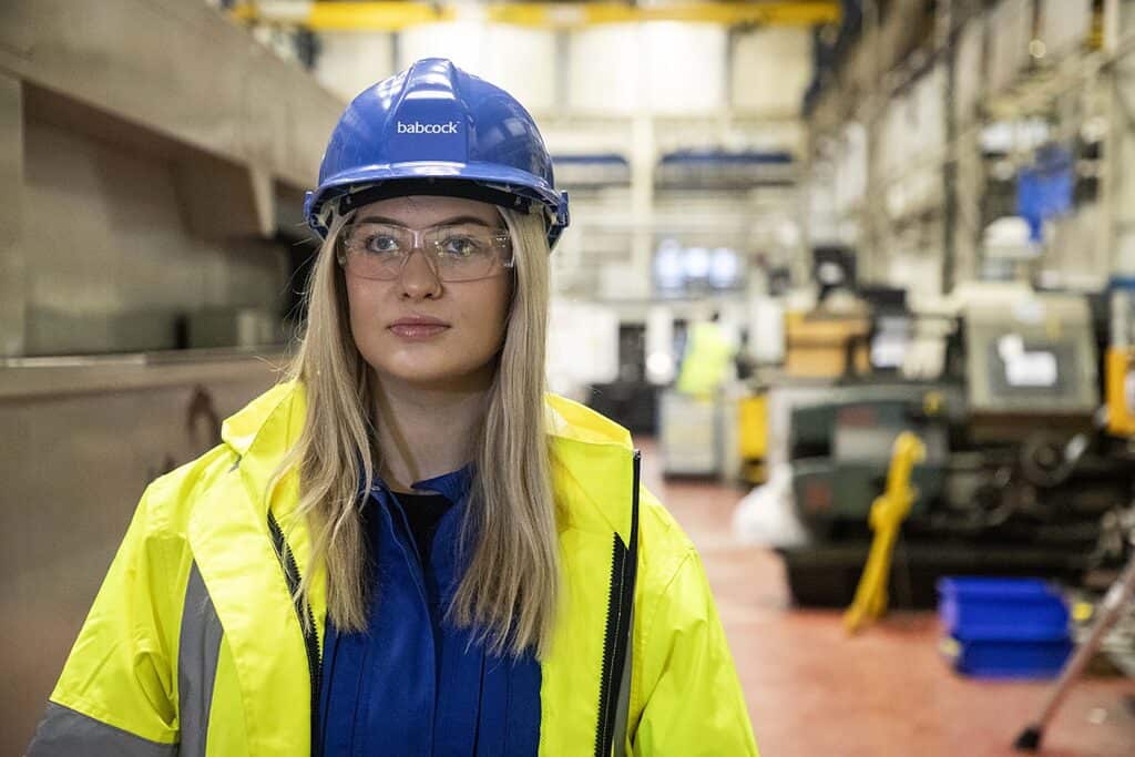 Young female Babcock employee in shipyard