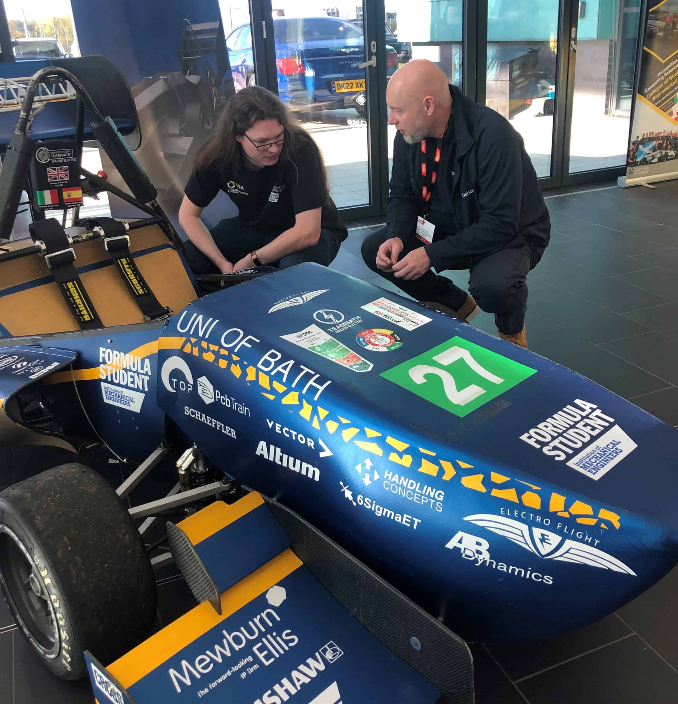Two people looking at a Formula Student race car