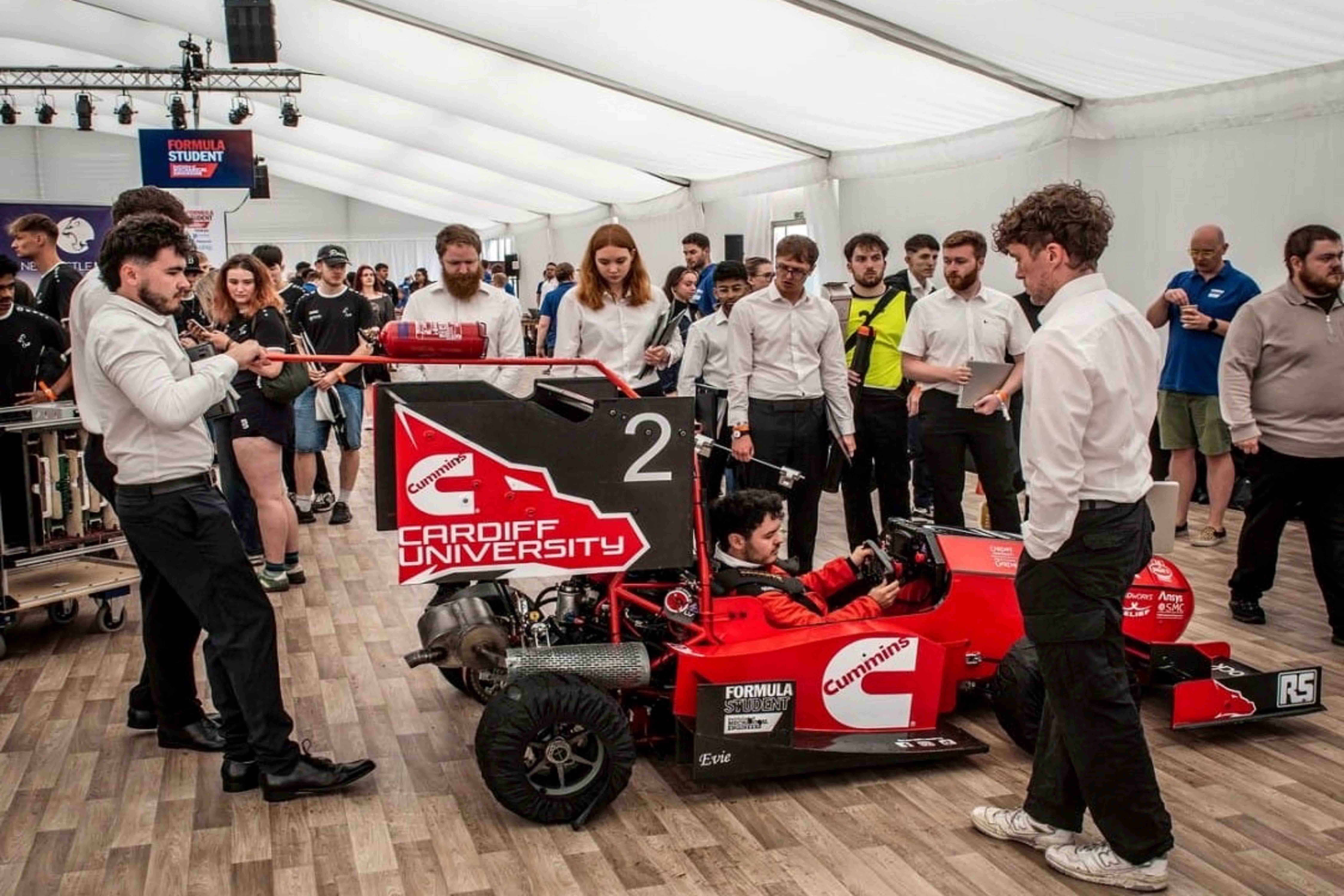 Students with racing car at Formula Student 2025