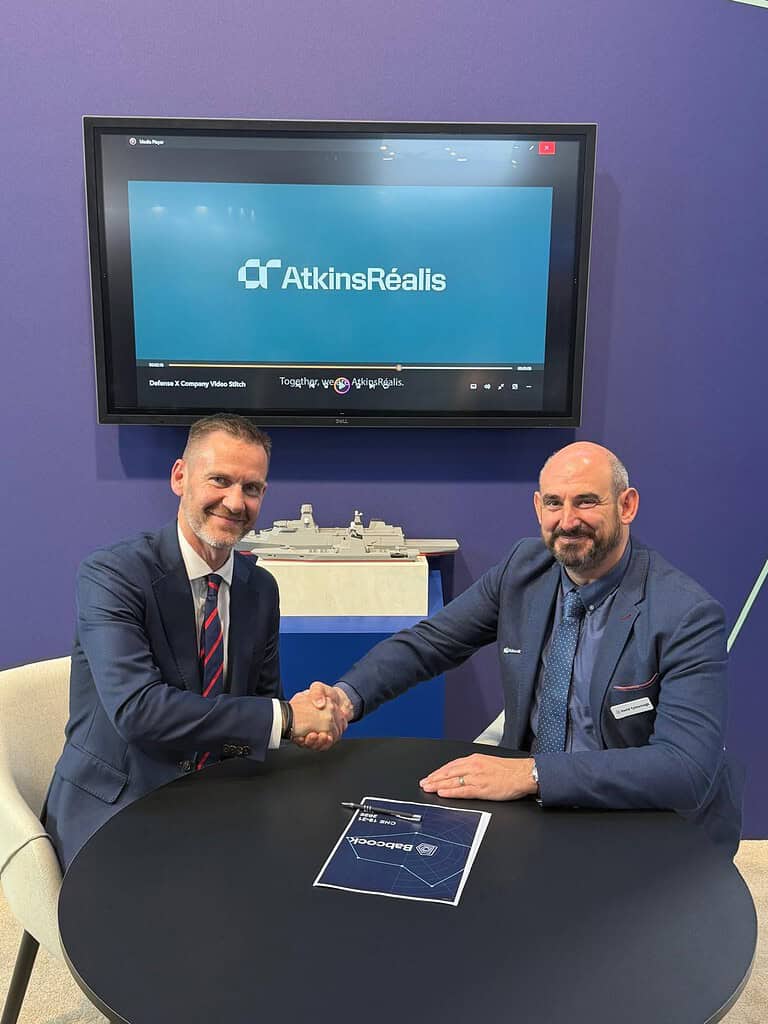 Representatives from Babcock and AtkinsRealis shake hands with a copy of new framework agreement in front of them