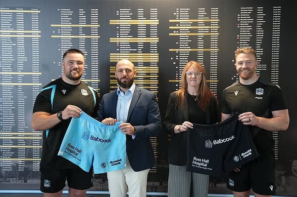 Representatives from Babcock and Glasgow Warriors holding home and away kit shorts with Babcock branding